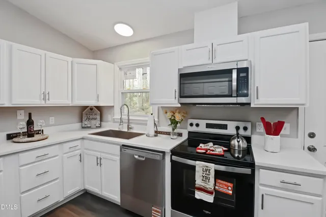a kitchen with granite countertop a refrigerator stove top oven and sink
