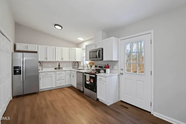a kitchen with granite countertop white cabinets and white appliances