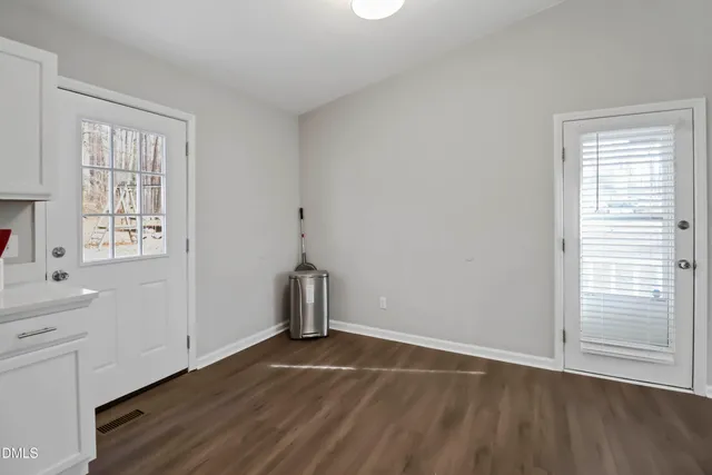 a view of empty room with wooden floor and window