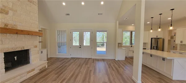 a view of a hallway with wooden floor and a fireplace