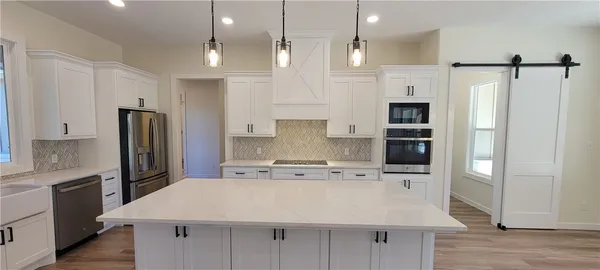 a kitchen with kitchen island stainless steel appliances a refrigerator sink and cabinets