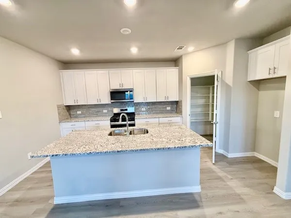a kitchen with stainless steel appliances granite countertop a sink and a stove