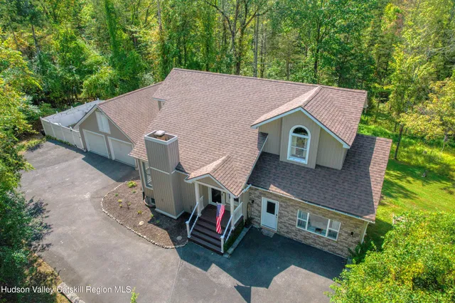 a aerial view of a house with a yard and large tree