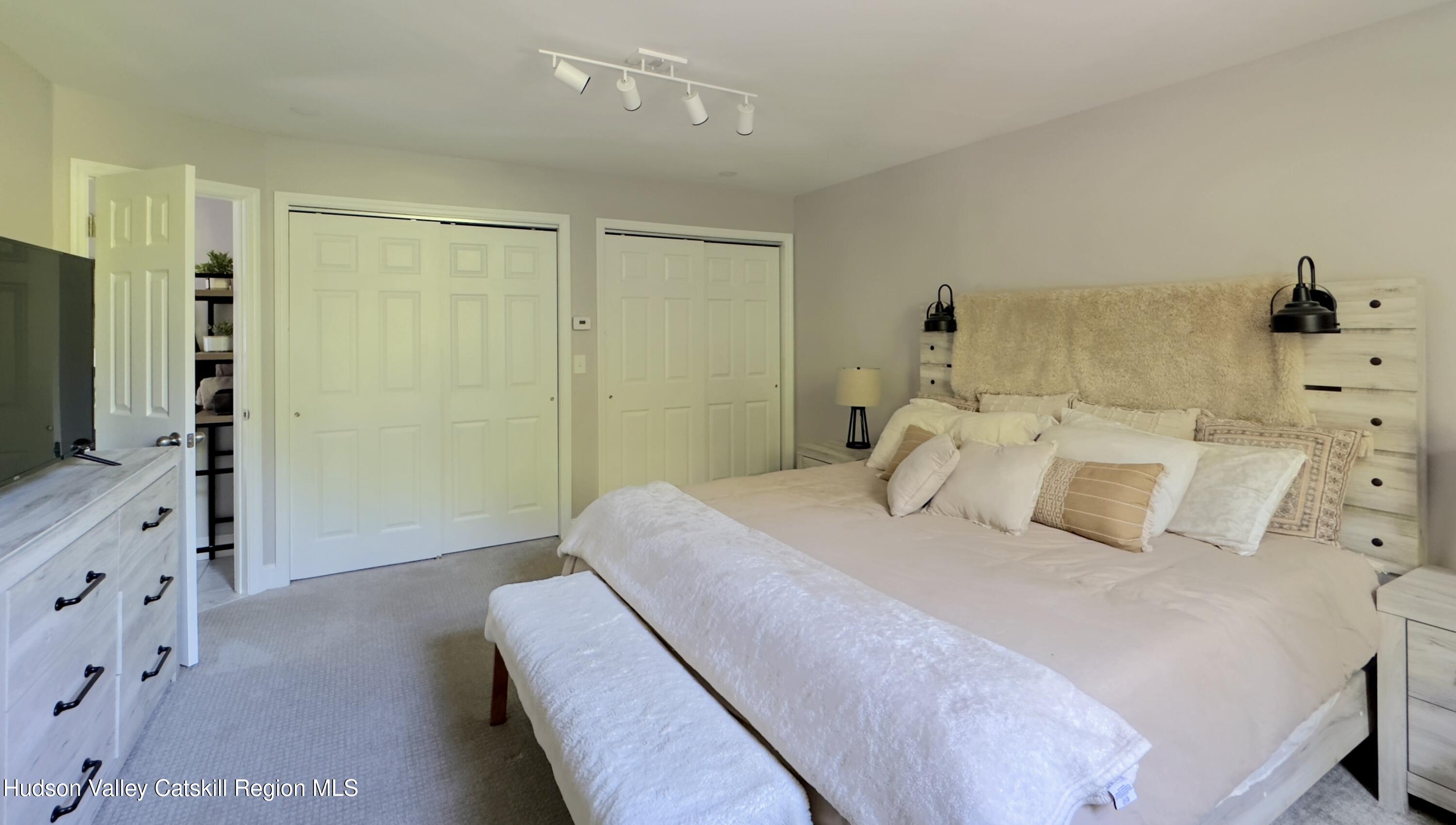 1801 Sleepy Hollow Road Athens, NY 12015 - Photo 18 of 34 a bedroom with a large bed and a flat tv screen on dresser