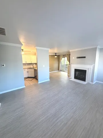 a view of a kitchen with kitchen island a sink wooden floor and wooden floor