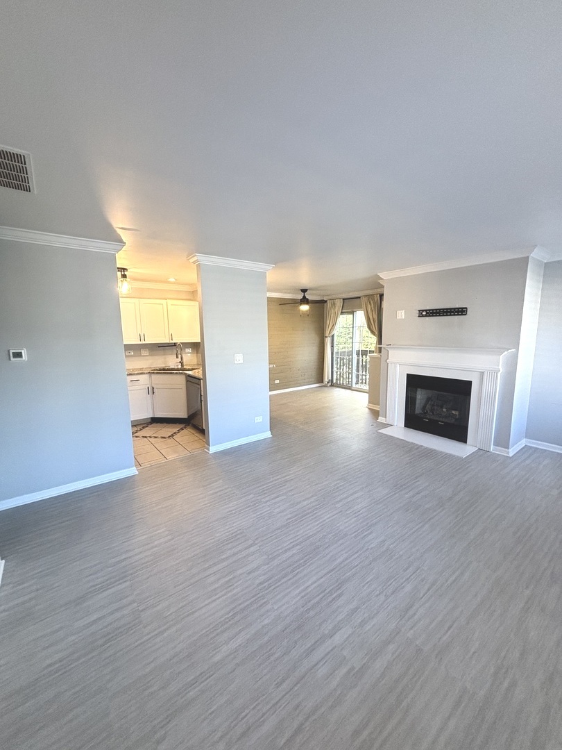 268 Windsor Court, Unit D South Elgin, IL 60177 - Photo 6 of 21 a view of empty room with wooden floor and fireplace