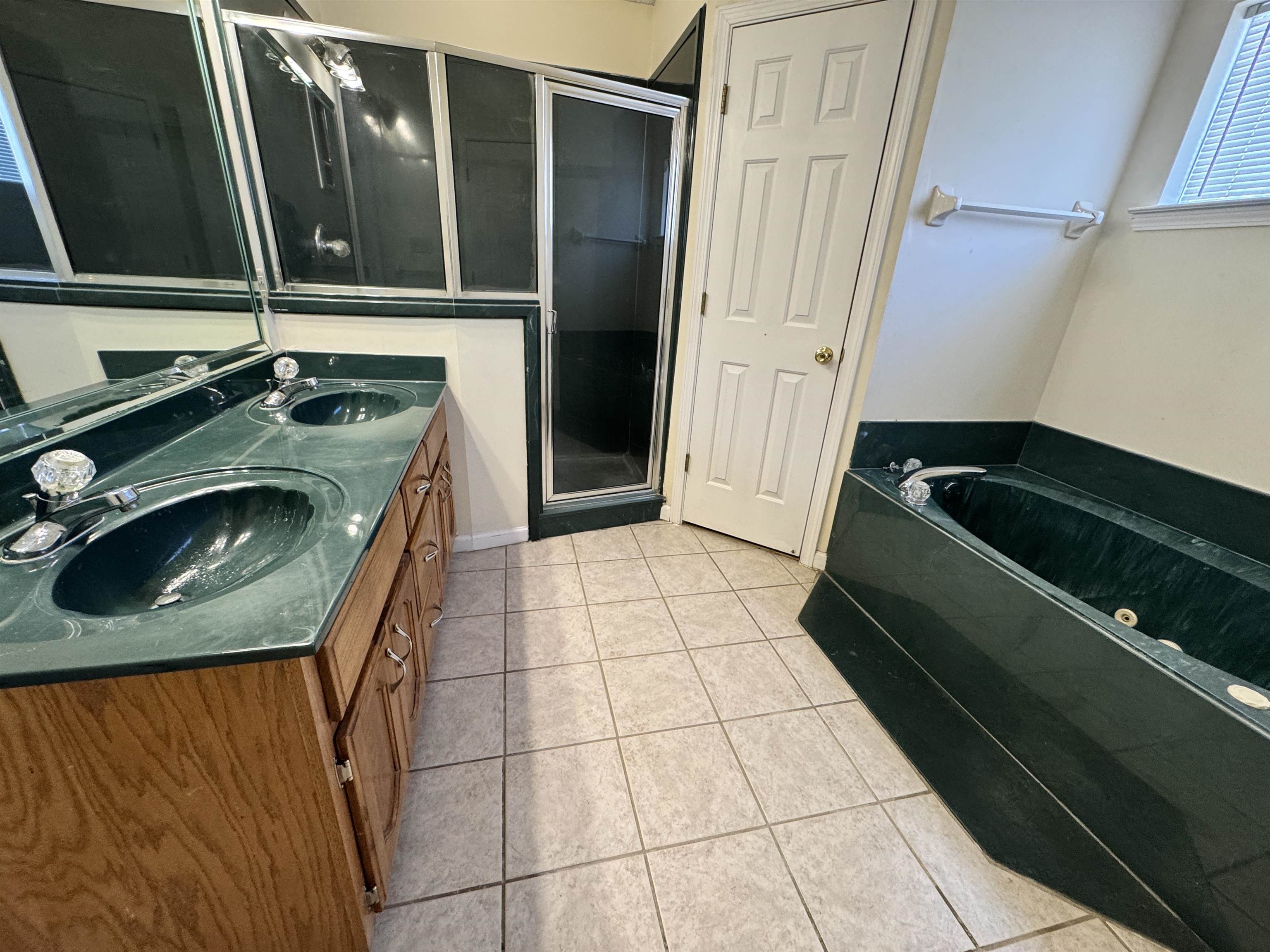 7916 Macon Road Memphis, TN 38018 - Photo 21 of 24 Bathroom featuring a tub with jets, double vanity, a stall shower, and light tile patterned flooring