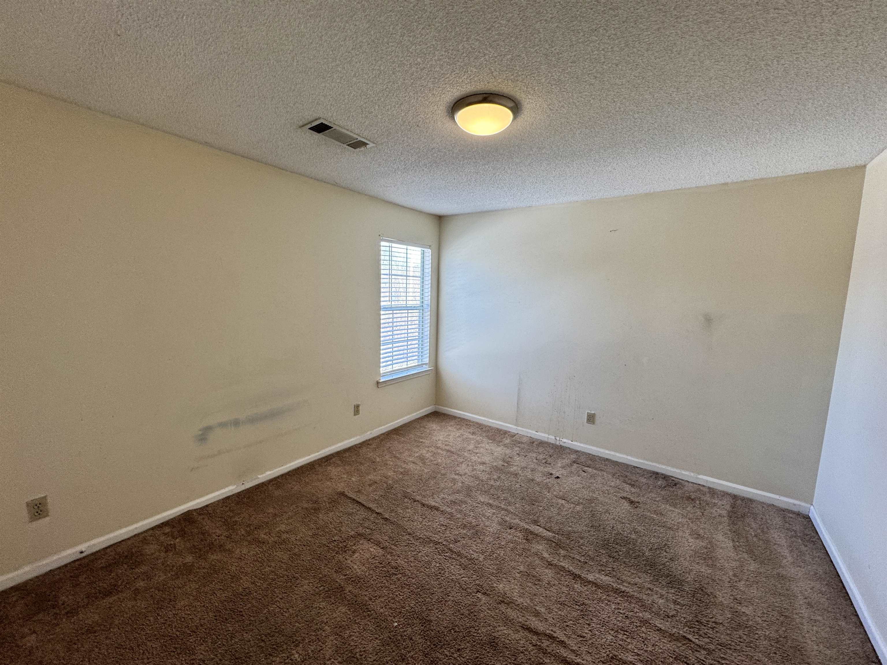 7916 Macon Road Memphis, TN 38018 - Photo 4 of 24 Empty room featuring carpet flooring and a textured ceiling
