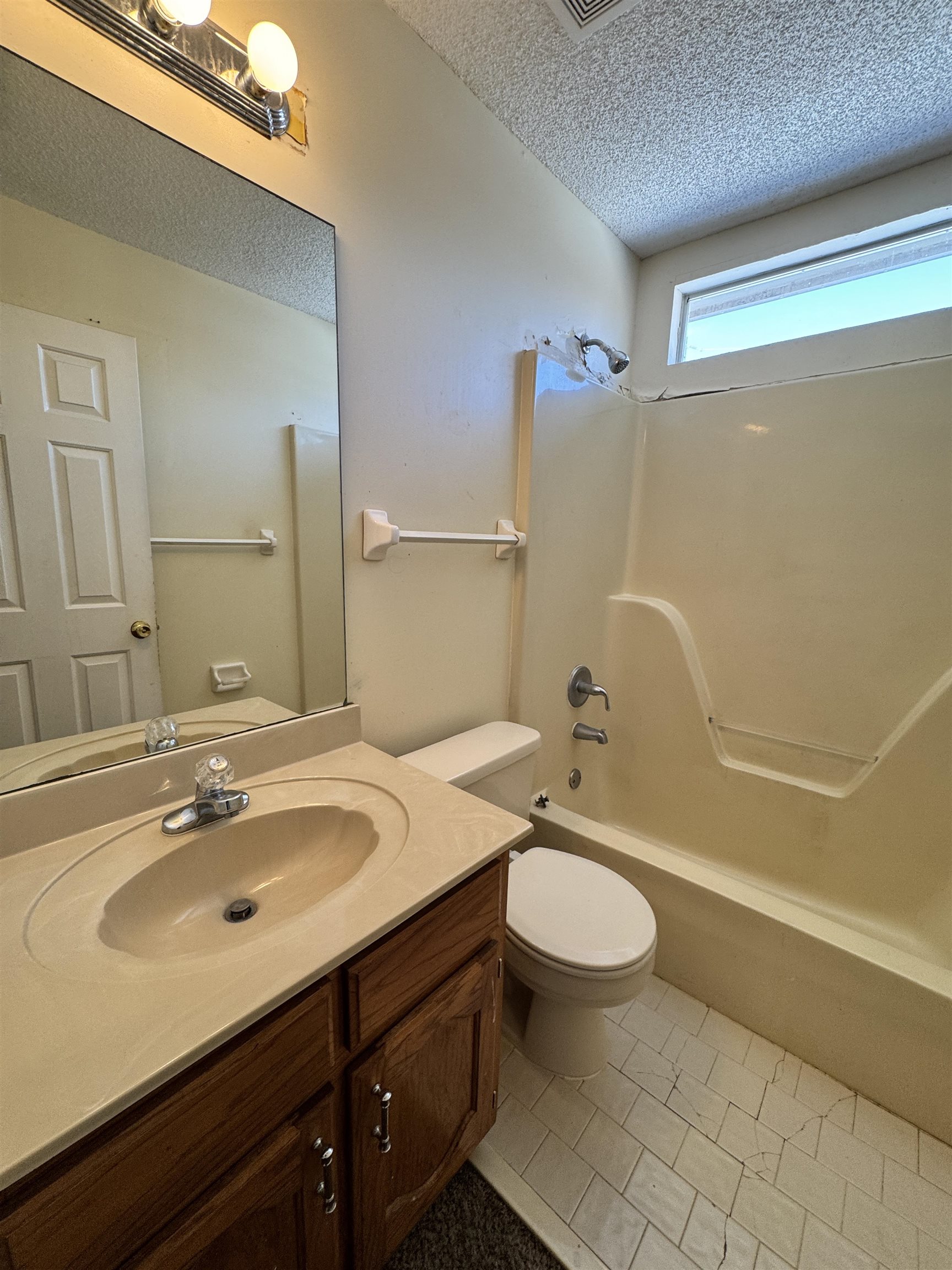 7916 Macon Road Memphis, TN 38018 - Photo 5 of 24 Bathroom with vanity, shower combination, a textured ceiling, and light tile patterned flooring
