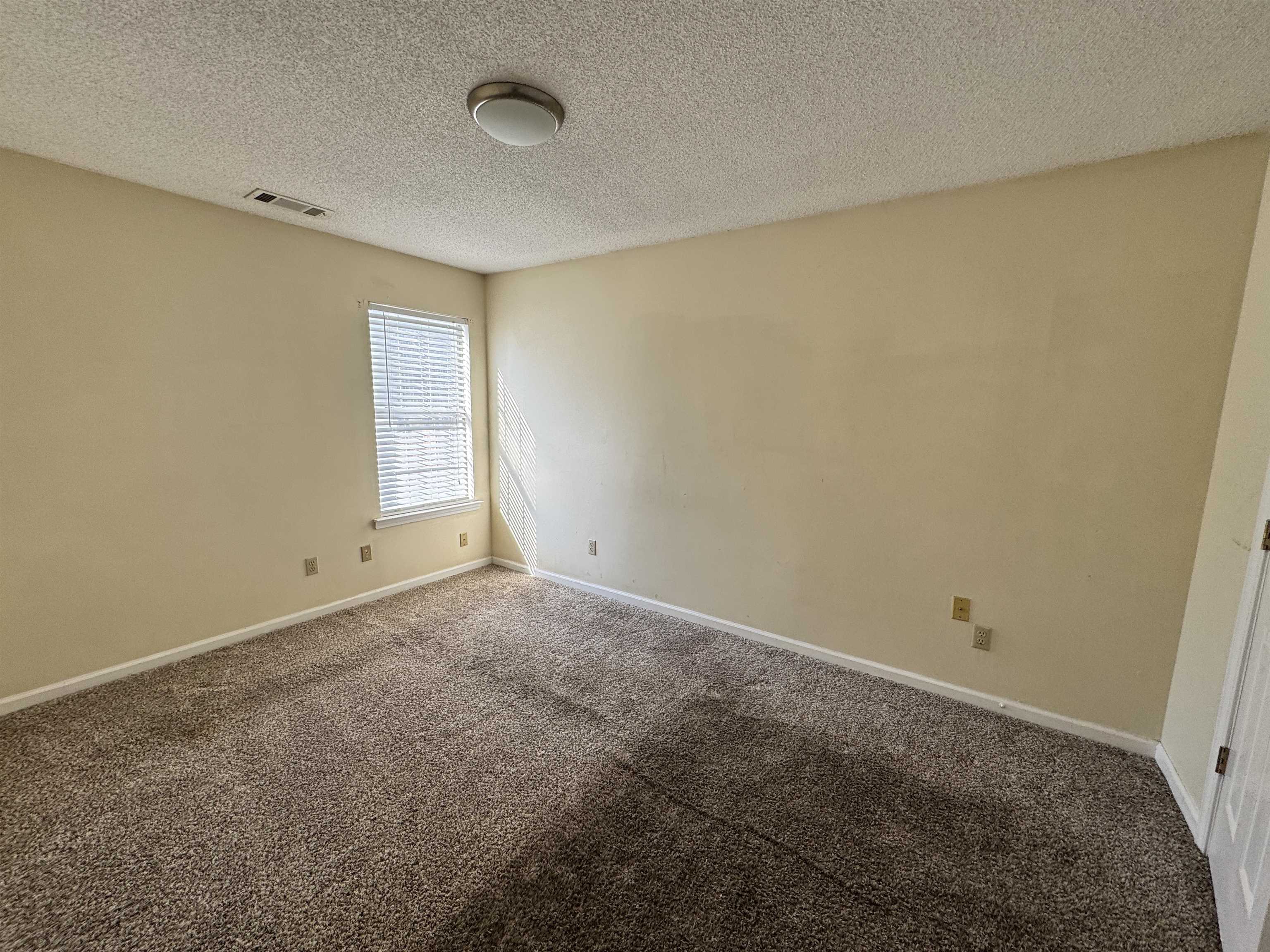 7916 Macon Road Memphis, TN 38018 - Photo 6 of 24 Carpeted spare room featuring baseboards and a textured ceiling