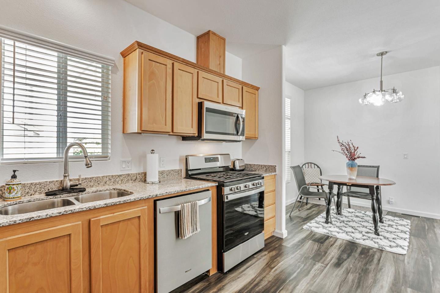 356 Reservation Road, Unit 68 Marina, CA 93933 - Photo 11 of 32 a kitchen with stainless steel appliances granite countertop a stove a sink dishwasher and microwave with wooden floor