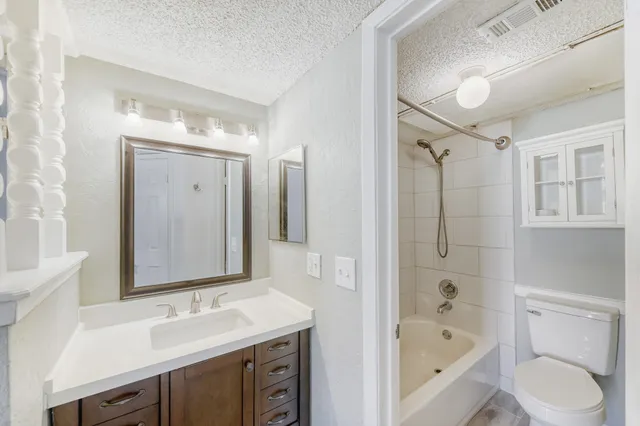 a bathroom with a tub sink toilet and mirror