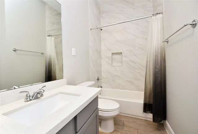 a bathroom with a bathtub shower sink vanity and toilet