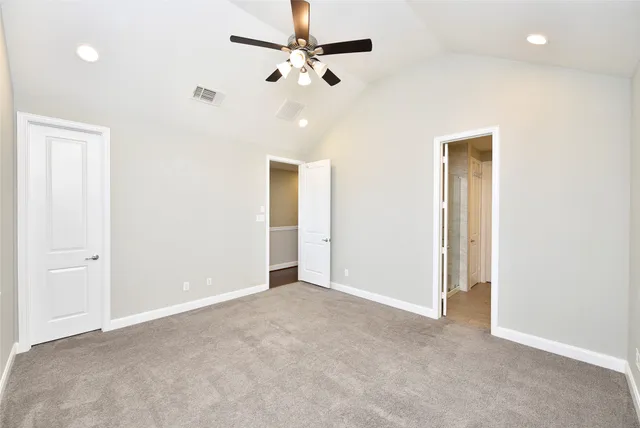 an empty room with ceiling fan and window