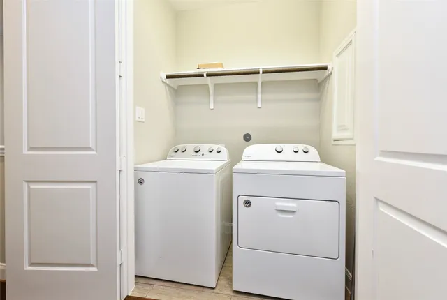 a view of a house with a barbeque and wooden stairs