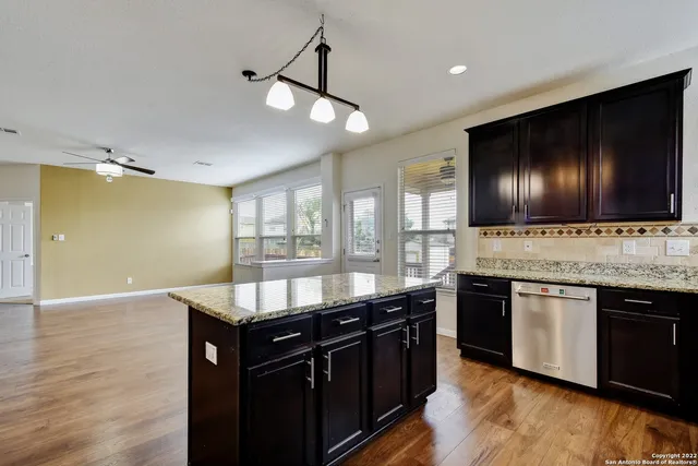 a kitchen with granite countertop stainless steel appliances and wooden floor