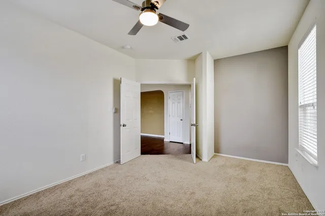 an empty room with a empty space and a ceiling fan