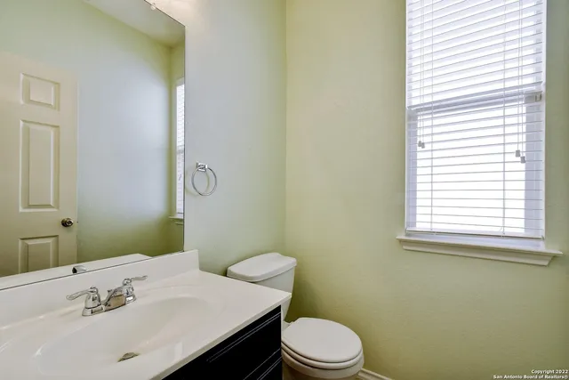 a bathroom with a sink a toilet and mirror