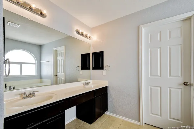 a bathroom with a double vanity sink and mirror