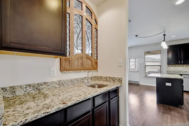 a kitchen with granite countertop sink and cabinets