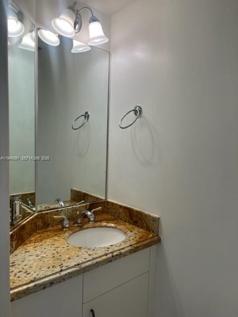701 Brickell Key Boulevard, Unit 1402 Miami, FL 33131 - Photo 12 of 12 a bathroom with a granite countertop sink and a mirror