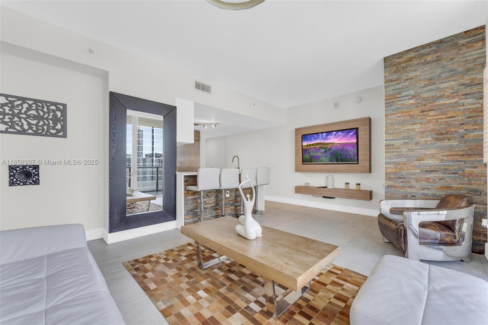 1300 Brickell Bay Drive, Unit 2511 Miami, FL 33131 - Photo 2 of 30 a living room with furniture and a flat screen tv