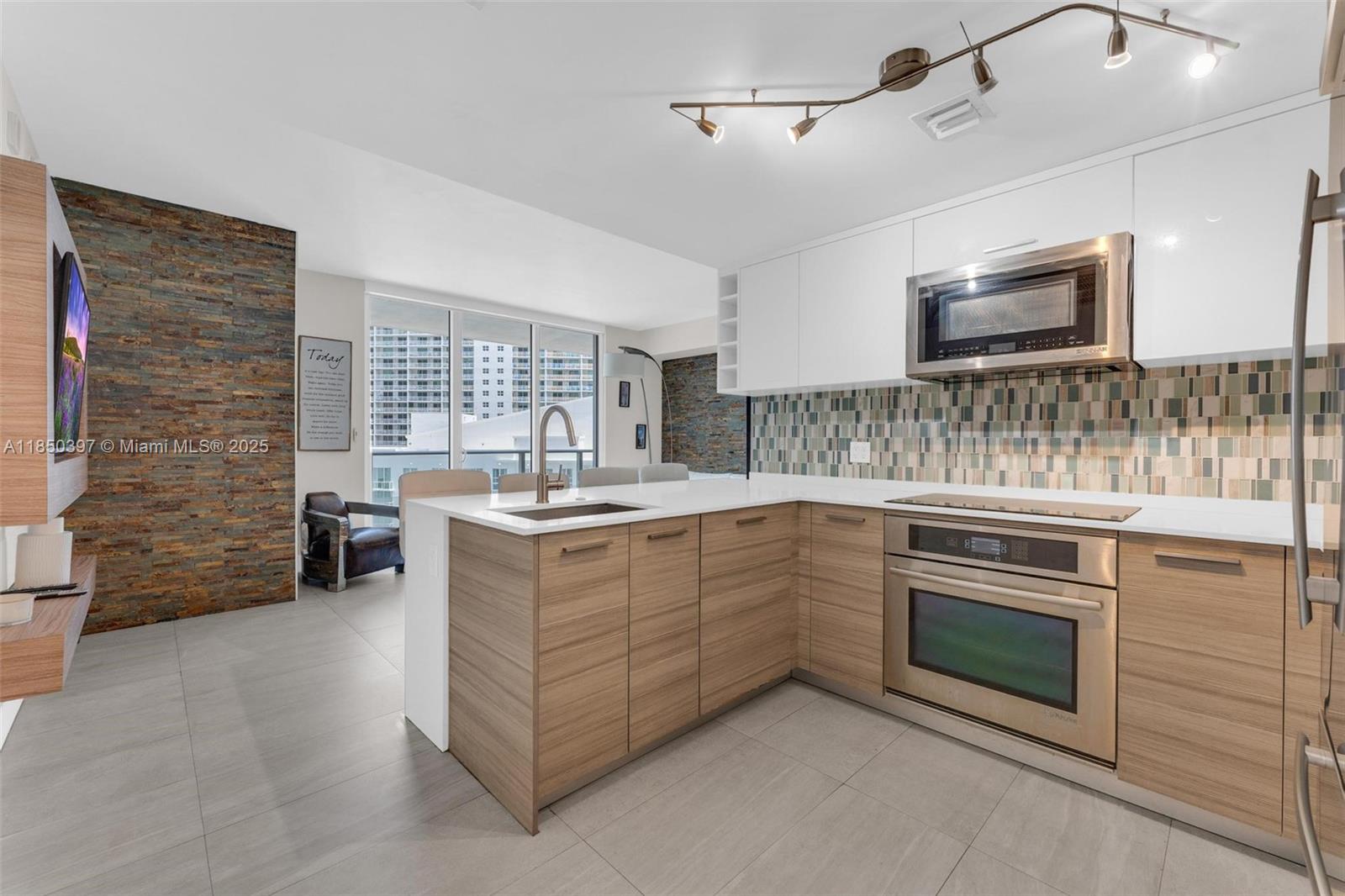 1300 Brickell Bay Drive, Unit 2511 Miami, FL 33131 - Photo 3 of 30 a kitchen with stainless steel appliances granite countertop a stove and cabinets