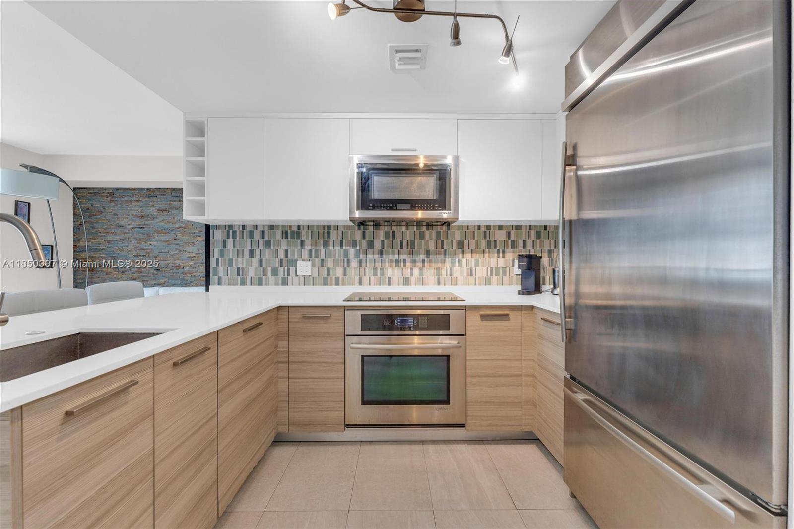 1300 Brickell Bay Drive, Unit 2511 Miami, FL 33131 - Photo 4 of 30 a kitchen with stainless steel appliances granite countertop a stove and a refrigerator
