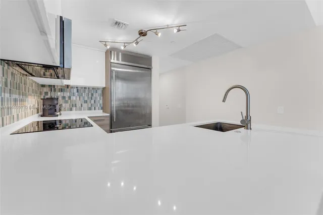 a kitchen with a sink and a refrigerator