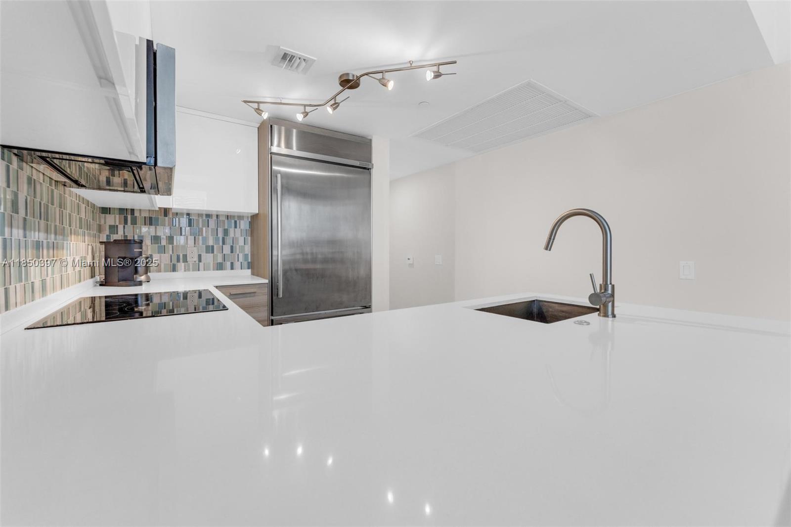 1300 Brickell Bay Drive, Unit 2511 Miami, FL 33131 - Photo 10 of 30 a kitchen with a sink and a refrigerator