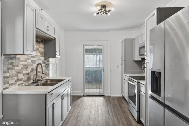 a kitchen with granite countertop a refrigerator stove and sink