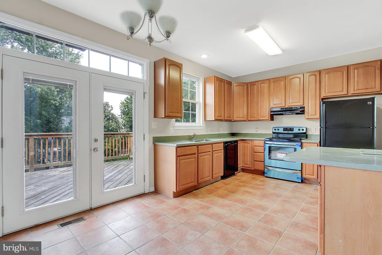 532 Grovethorn Road Baltimore, MD 21220 - Photo 5 of 30 a kitchen with granite countertop a stove top oven a sink dishwasher a dining table and chairs with wooden floor