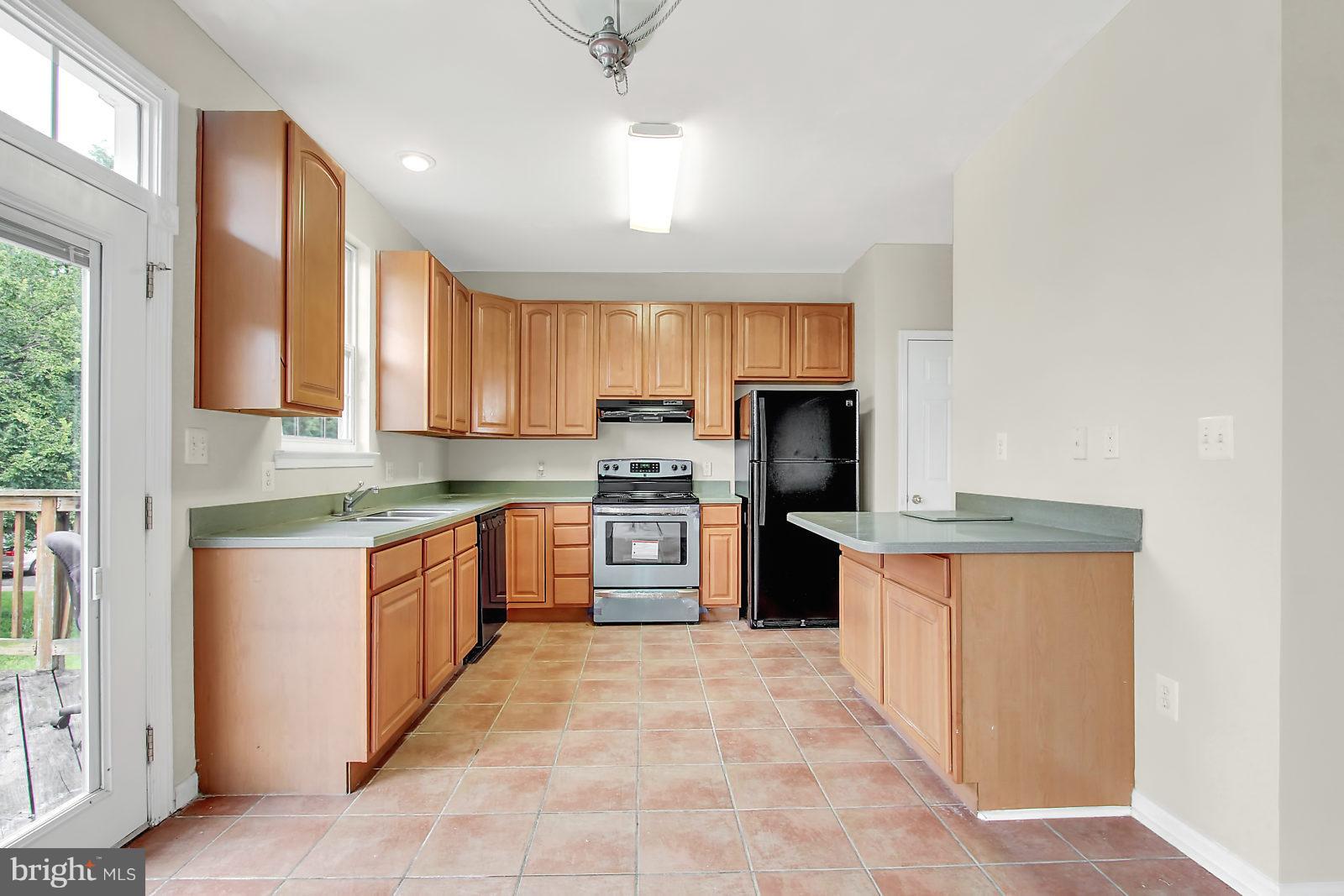 532 Grovethorn Road Baltimore, MD 21220 - Photo 6 of 30 a large kitchen with stainless steel appliances granite countertop a stove refrigerator sink and cabinets
