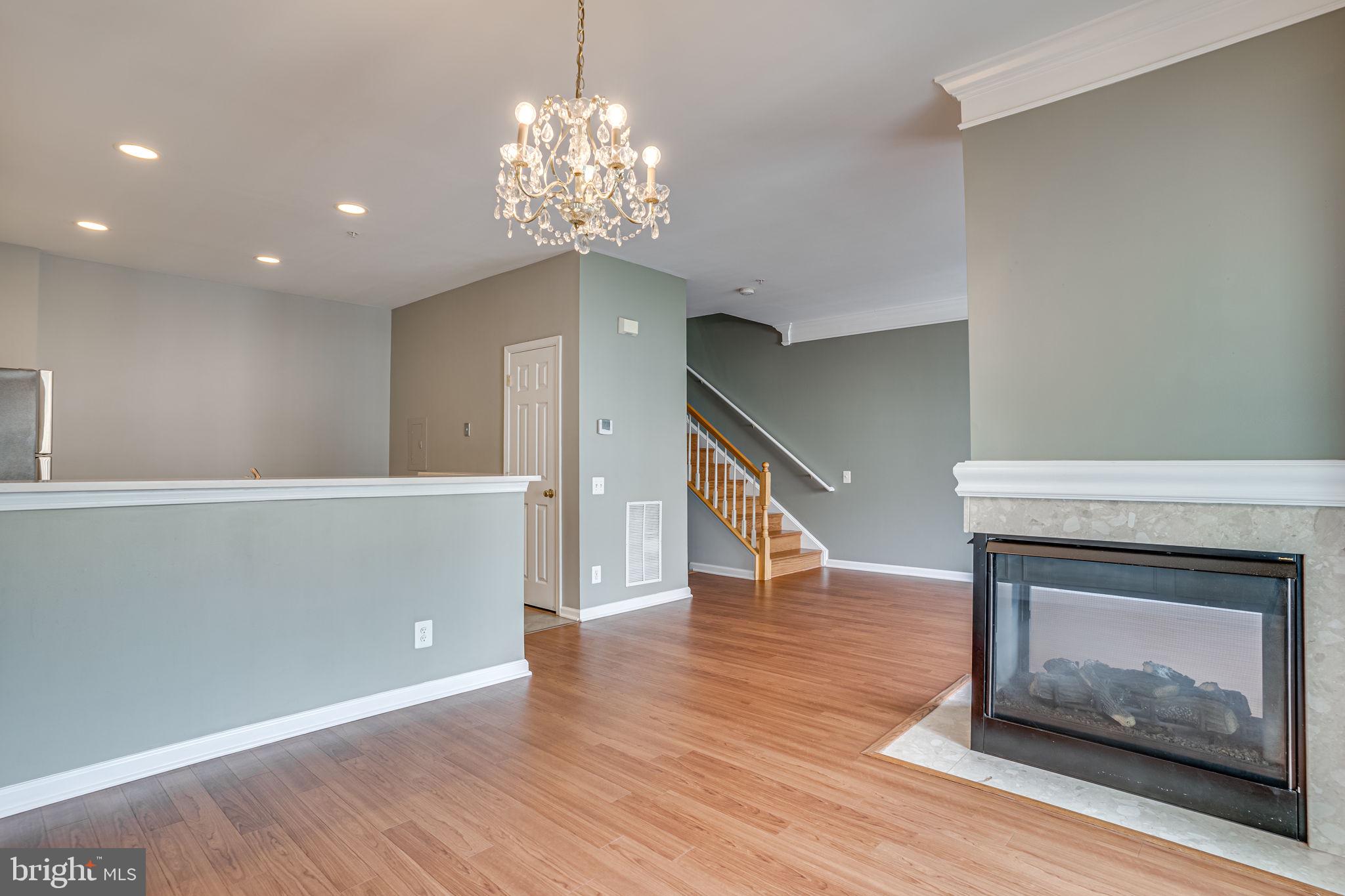 6321 Eagle Ridge Lane, Unit B Alexandria, VA 22312 - Photo 13 of 39 a view of an empty room with wooden floor fireplace and a window