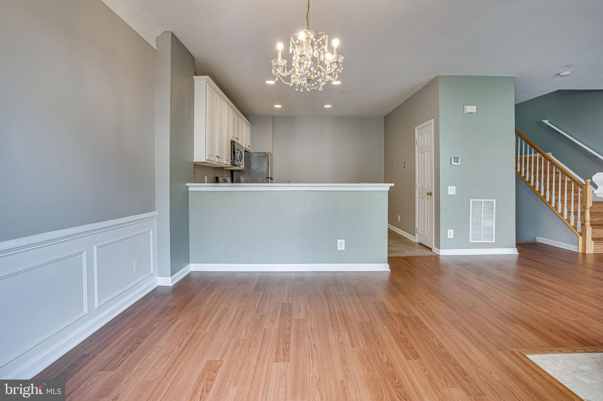 6321 Eagle Ridge Lane, Unit B Alexandria, VA 22312 - Photo 14 of 39 a view of a room with wooden floor and a kitchen