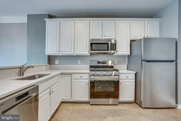 a kitchen with cabinets stainless steel appliances and a sink