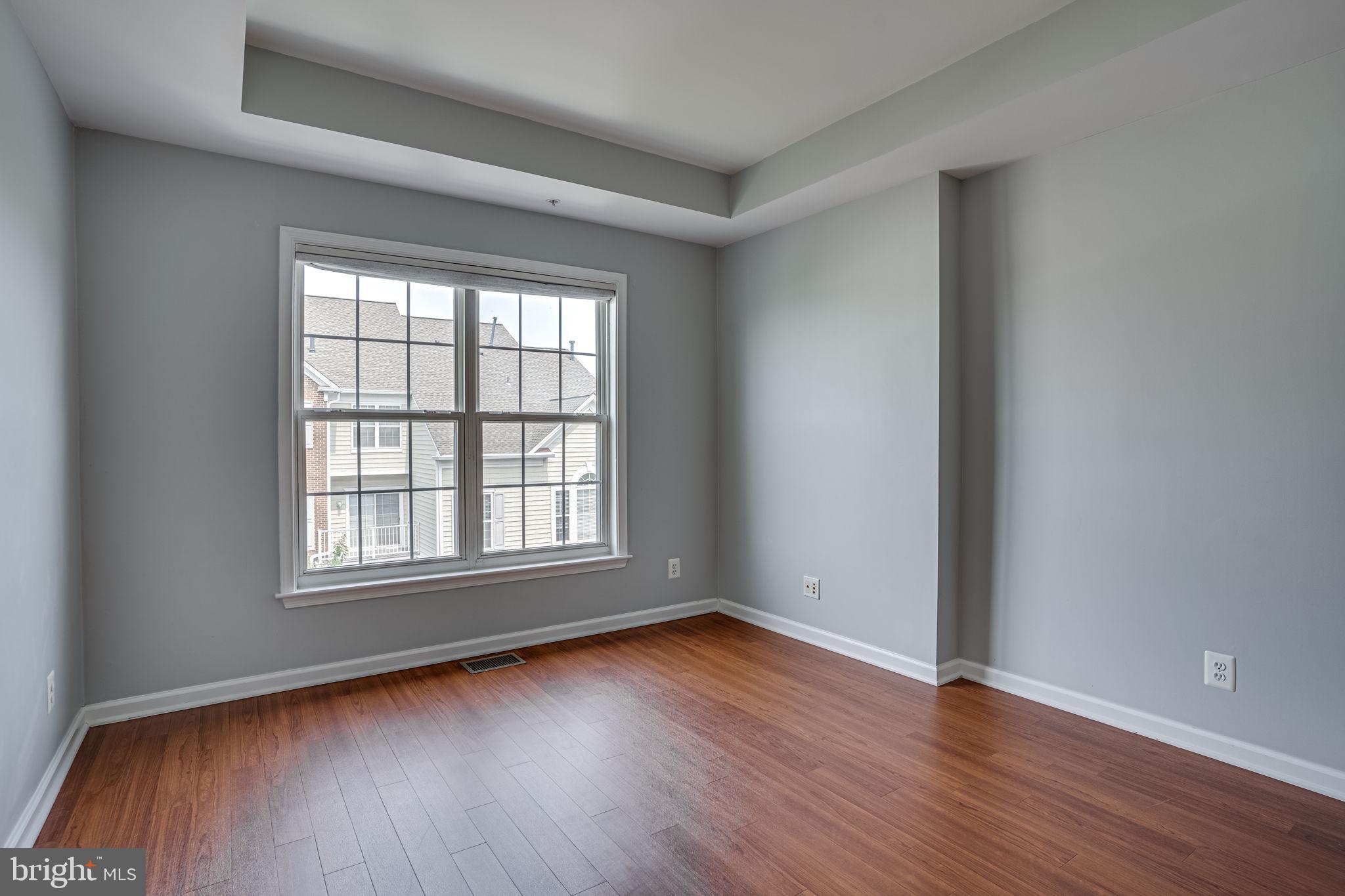 6321 Eagle Ridge Lane, Unit B Alexandria, VA 22312 - Photo 25 of 39 an empty room with wooden floor and windows