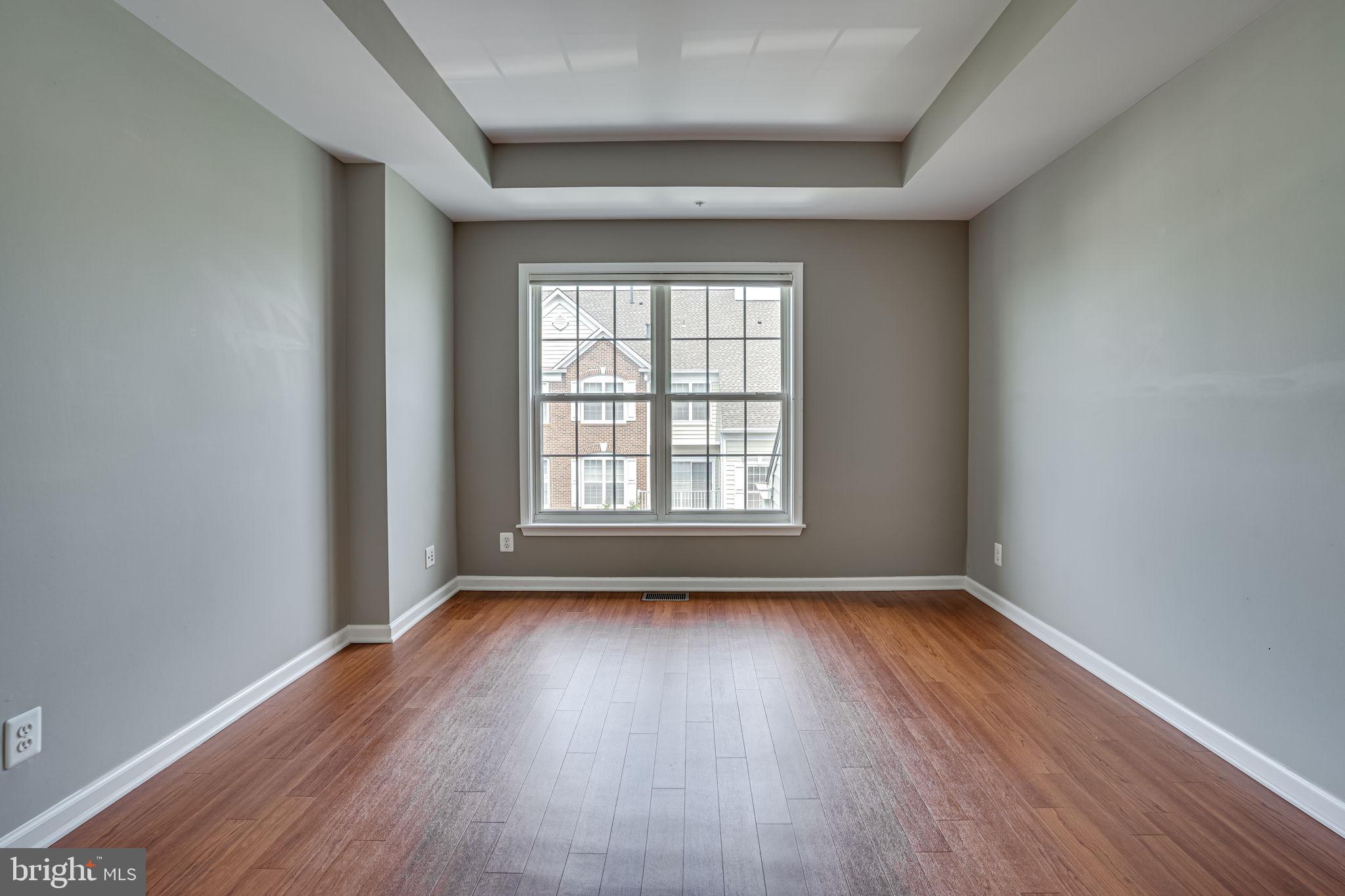6321 Eagle Ridge Lane, Unit B Alexandria, VA 22312 - Photo 27 of 39 a view of an empty room with wooden floor and a window