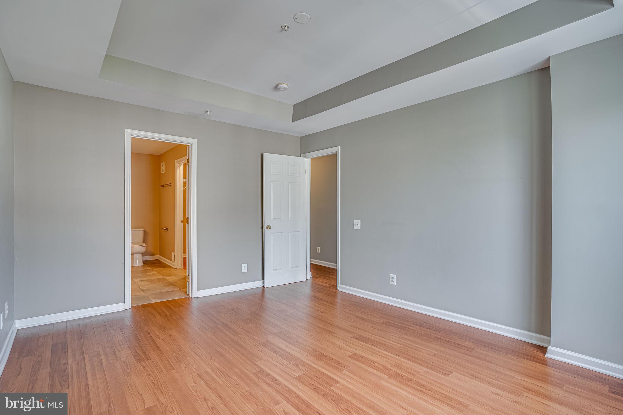 6321 Eagle Ridge Lane, Unit B Alexandria, VA 22312 - Photo 28 of 39 a view of an empty room with wooden floor and a window