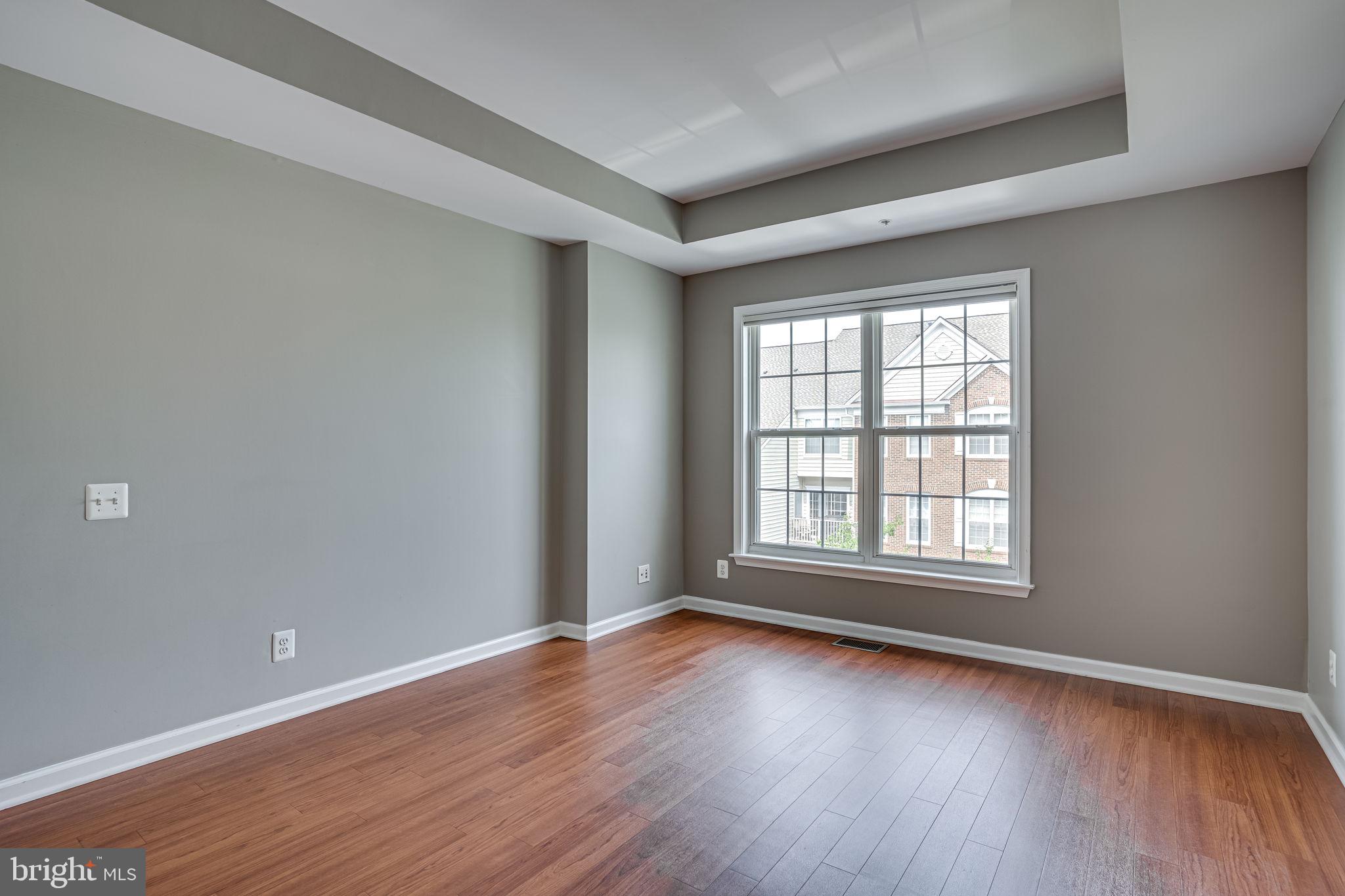 6321 Eagle Ridge Lane, Unit B Alexandria, VA 22312 - Photo 29 of 39 an empty room with wooden floor and windows