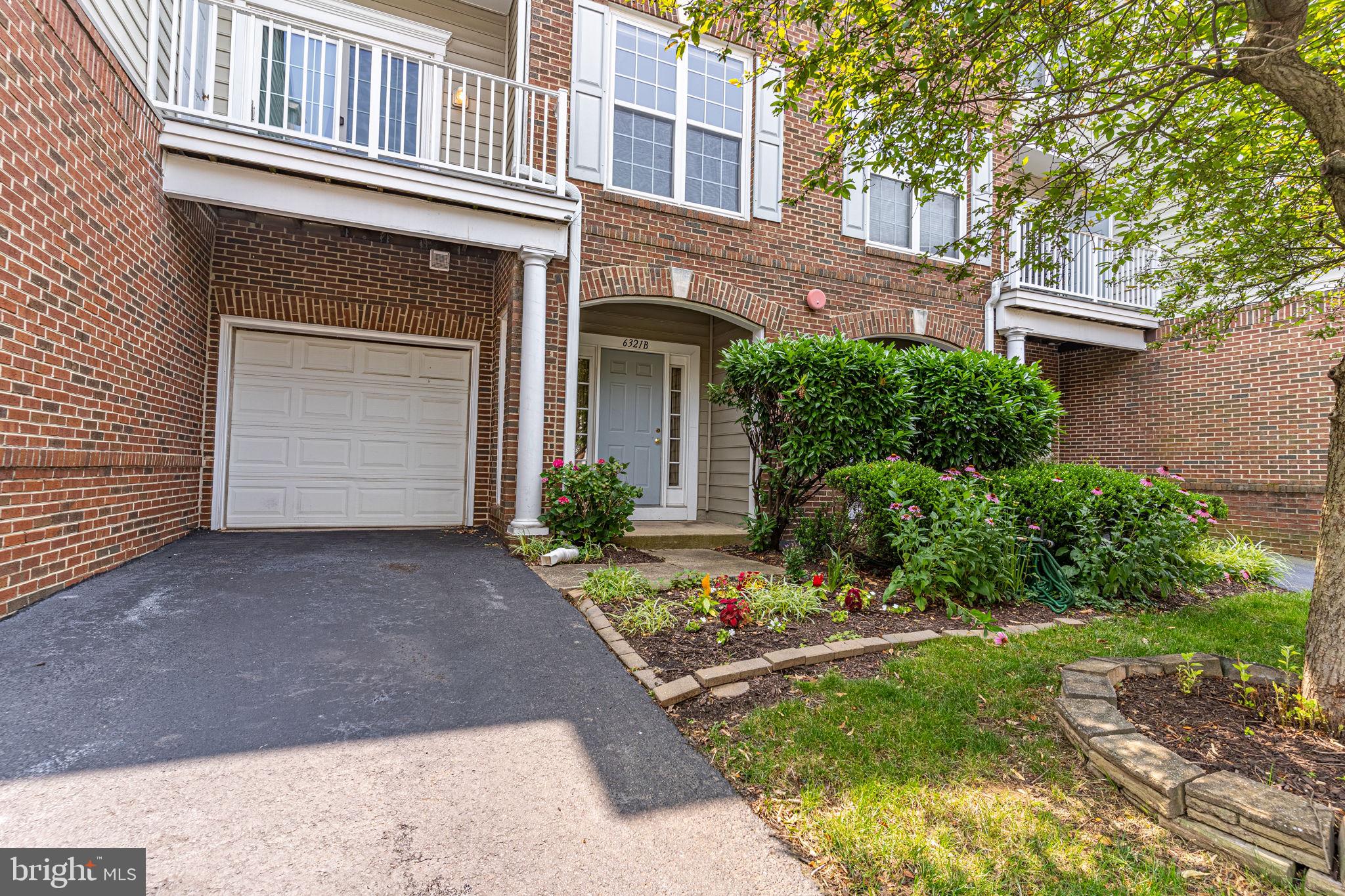 6321 Eagle Ridge Lane, Unit B Alexandria, VA 22312 - Photo 3 of 39 a front view of a house with a yard and garage