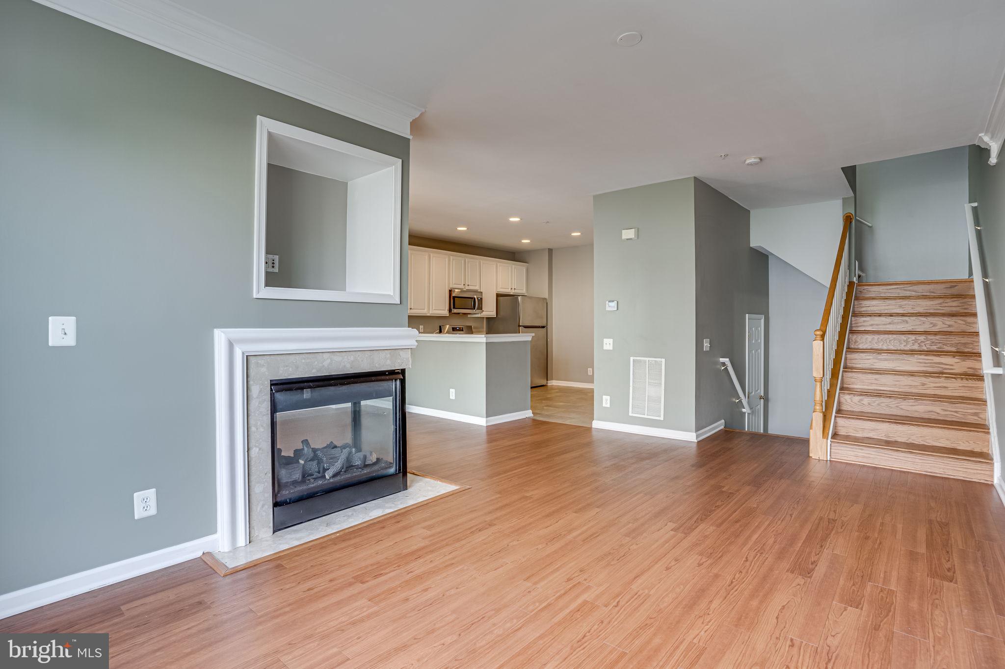6321 Eagle Ridge Lane, Unit B Alexandria, VA 22312 - Photo 9 of 39 a view of a hallway with wooden floor and a fireplace