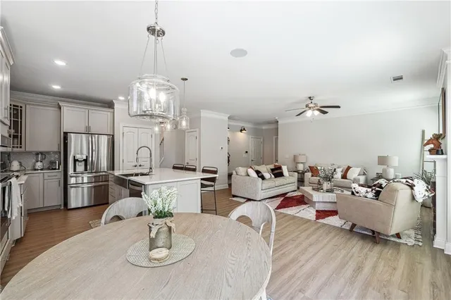 a living room with lots of white furniture and wooden floor