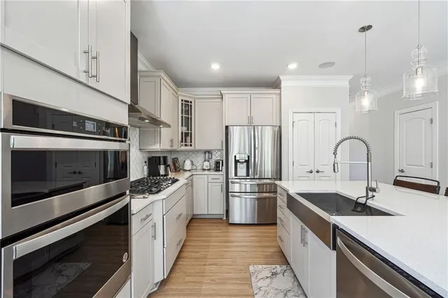 a kitchen with stainless steel appliances a sink a stove and cabinets