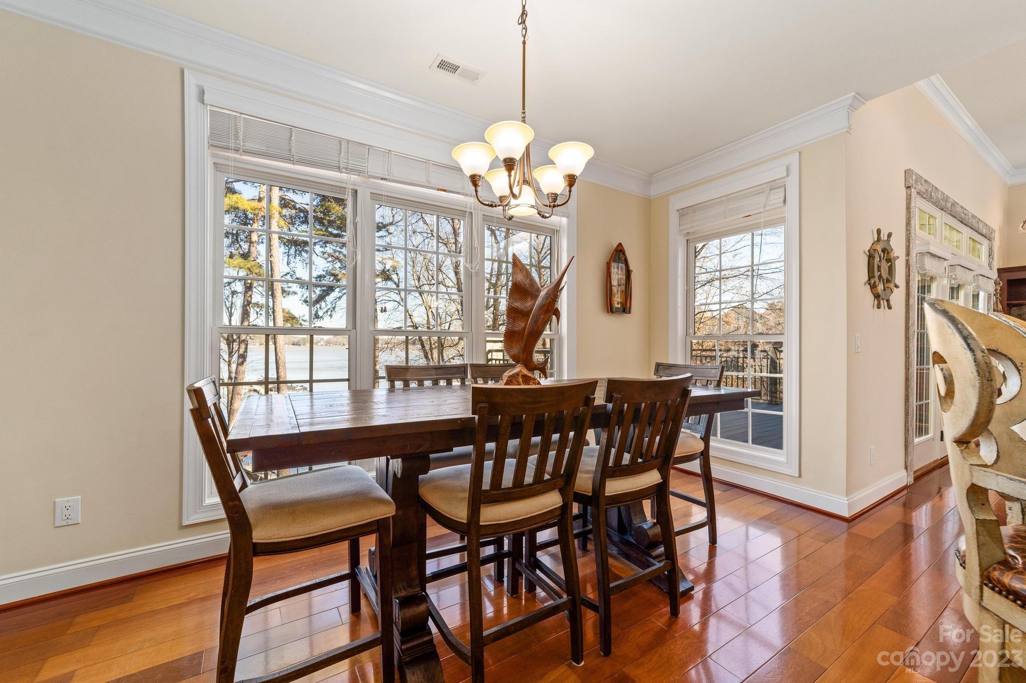 8065 Bay Pointe Drive Denver, NC 28037 - Photo 12 of 40 a view of a dining room with furniture a chandelier and wooden floor