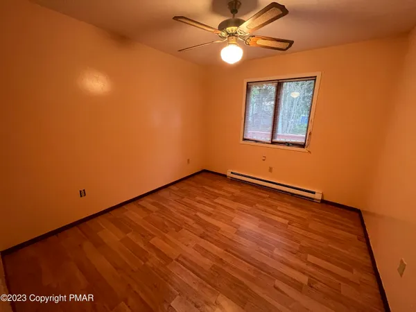 a view of room with window ceiling fan and hardwood floor