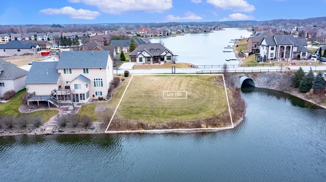 an aerial view of residential houses with outdoor space and lake view