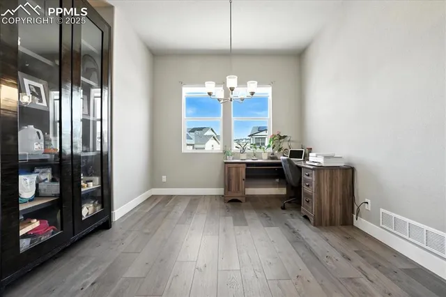 a view of a room with wooden floor and furniture
