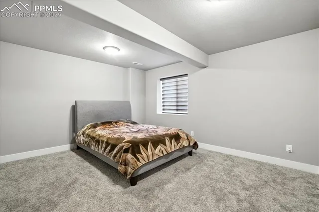 a bed sitting in a spacious bedroom next to a window