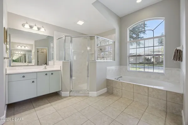 a spacious bathroom with a double vanity sink a mirror and a shower